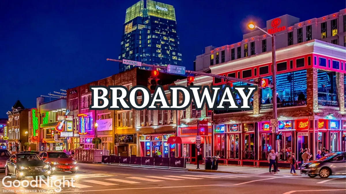 This image captures a bustling Nashville street at night, illuminated by vibrant neon signs and packed with people enjoying live music venues, dining, and shopping. The lively crowd and bright lights convey the energy and excitement of the city's nightlife.
